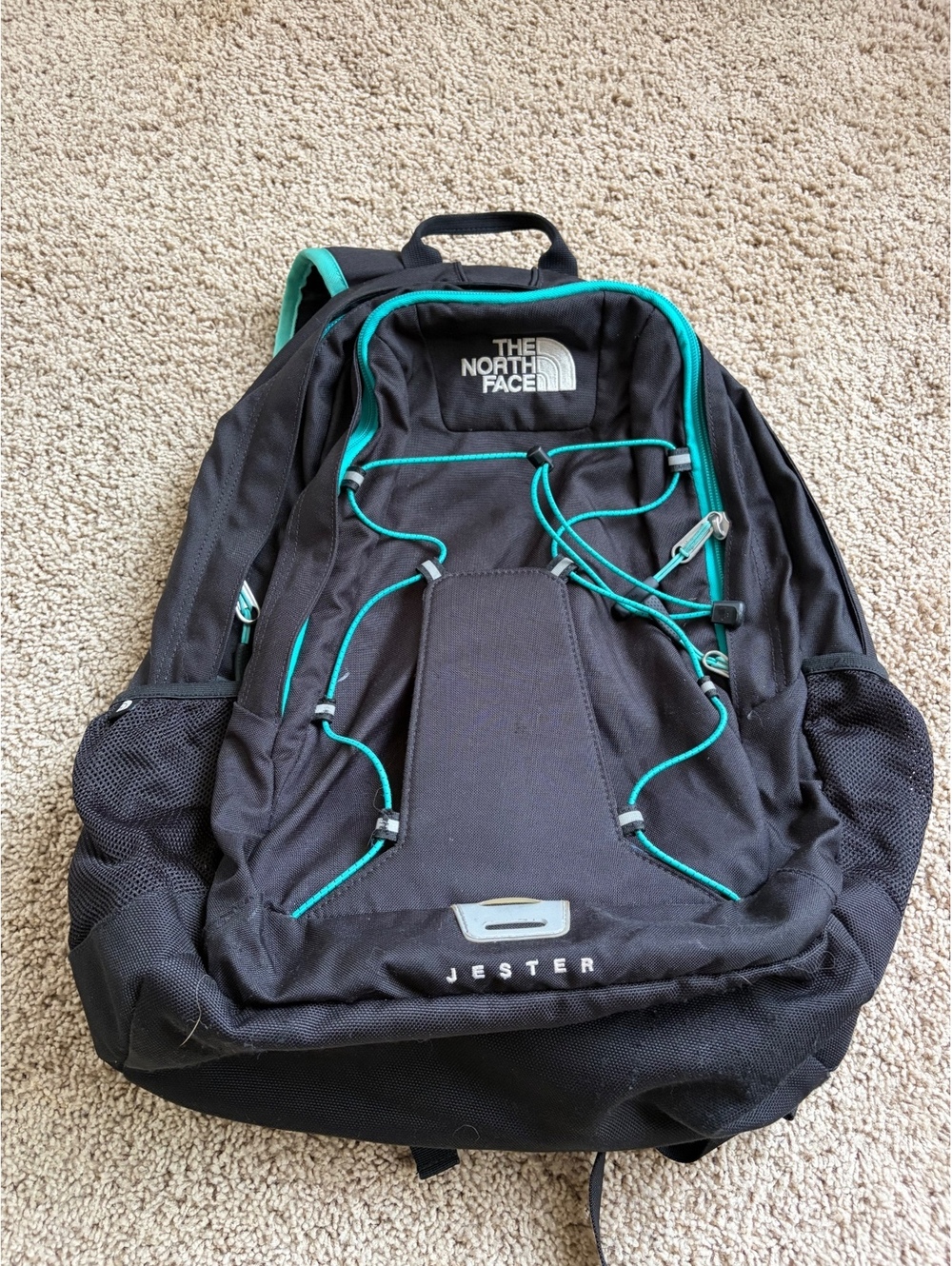 The North Face Jester Backpack black features striking teal bungee cords